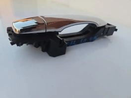 Ручка двери задняя правая Nissan X-Trail T32 80640-4CM0A в руке на фоне стеллажа