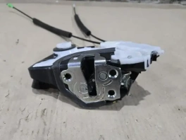 Замок двери Toyota Prius 4 XW50 передний левый 295100-5902 крупным планом на рабочем столе мастера