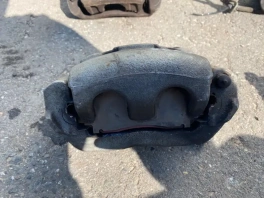 Суппорт тормозной передний правый Mitsubishi Outlander 3 GF 2012-2023 OEM 4605A044 на фоне склада с наклейкой инвентаризации